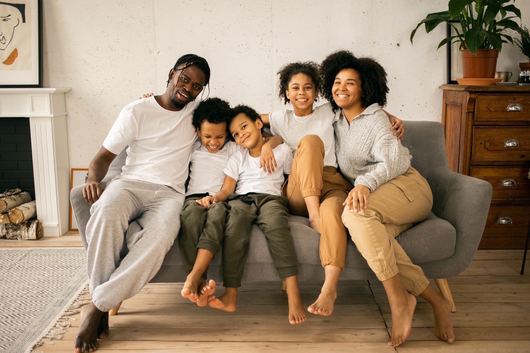 A family of five sitting together and smiling at home